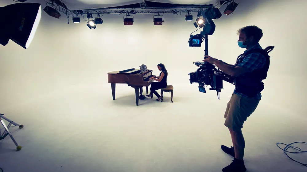 Steadicam shot of a pianist in a white cyc studio