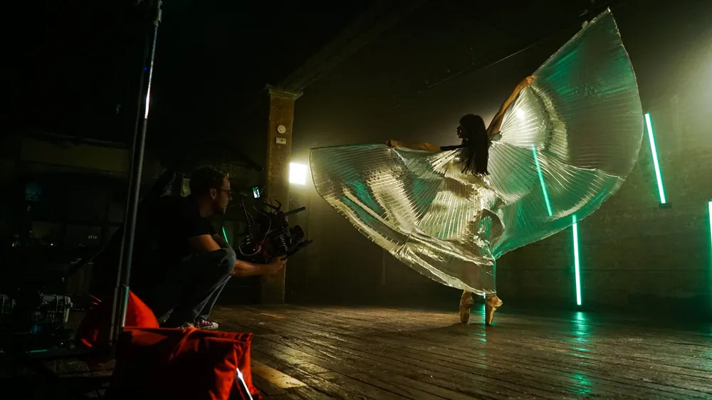 Dancer with flowing fabric on a dark stage